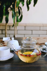 Top view of glass teapot and cups of tea on a table at restaurant close up. Tea ceremony. Holiday concept. Hot winter drinks. 