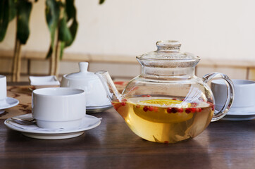 Top view of glass teapot and cups of tea on a table at restaurant close up. Tea ceremony. Holiday concept. Hot winter drinks. 