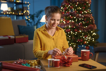 Woman wrapping Christmas gifts at home