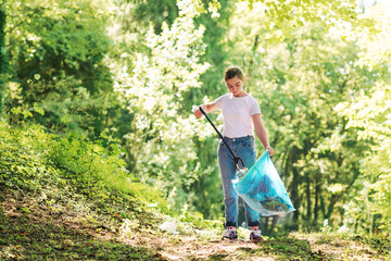 Girl cleaning up the forest and collecting trash