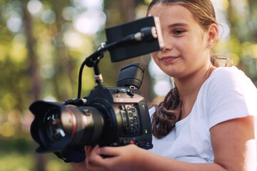 Cute girl shooting a video with a professional video camera