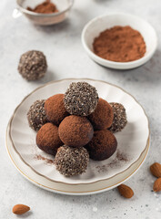 Chia seeds cacao bliss balls served on white plate. healthy raw vegan dessert. vertical image. closeup