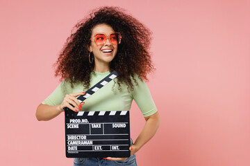 Exultant happy vivid young curly latin woman 20s wears mint t-shirt sunglasses look aside holding...