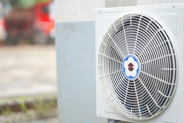 The air conditioner fan on the outer wall of the building for cooling.