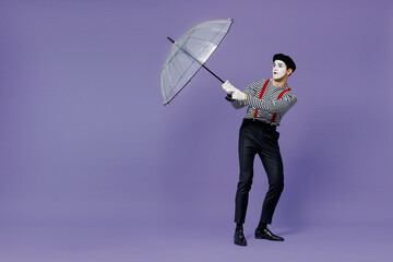 Full size body length young mime man with white face mask wears striped shirt beret hold...