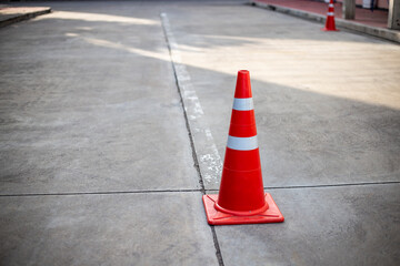 Orange traffic cones on cement road surface.