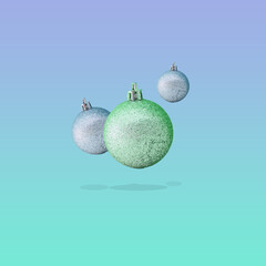 Flying silver decorations on blue background. Christmas and new year concept. Still life, minimalism