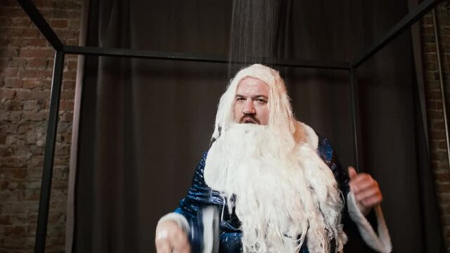 Comical crazy Santa Claus, Father Frost in blue costume takes shower, funny concept of Christmas and New Year. Tired actor playing Santa relaxing after party and performance, takes off clothes, beard