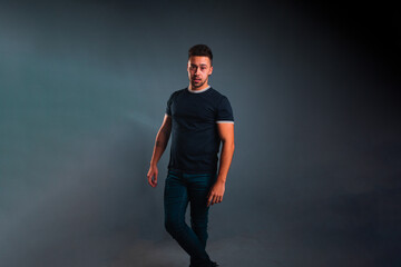 Young caucasian man portrait in a photography studio with a blue background.