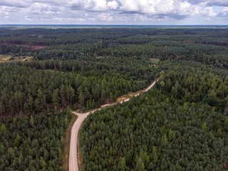 Areal plane drone photography view of gravel forest car truck road and large forest.