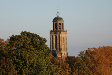 The tower of the Great Church in the city of Deventer, the Netherlands, can be seen above the colorful trees in autumn