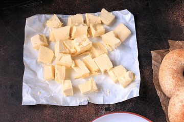 Fresh, organic Butter on white paper, dairy farm product. Dark background, top view.