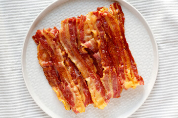 Homemade Oven Baked Bacon on a  Plate, top view. Flat lay, overhead, from above. Close-up.