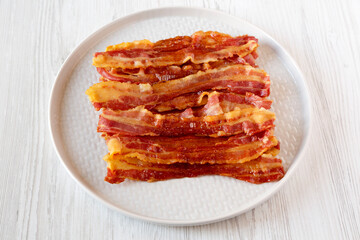 Homemade Greasy Oven Baked Bacon on a Gray Plate, side view.