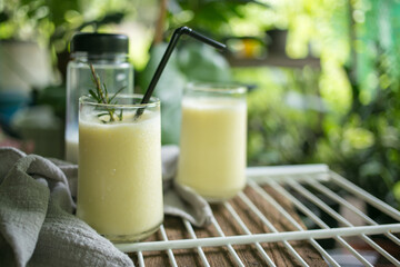 Corn juice smoothie on white rack placed on wood and plant backdrop in home garden pots. horizontal