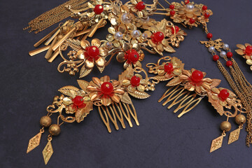 Chinese traditional hairpins hair clips on a grey concrete background. Traditional Chinese women's jewelry, gold hairpins with red gems