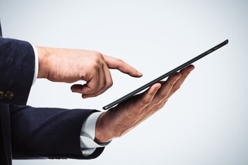 Businessman holds digital tablet and clicks on screen, close up. Search concept