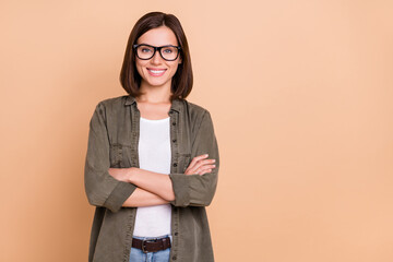 Photo of self-assured freelancer lady crossed arms wear eyeglasses khaki shirt isolated beige color...