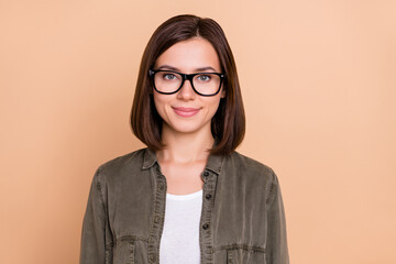 Photo of confident cheerful nice pretty lady look camera wear eyeglasses khaki shirt isolated beige color background