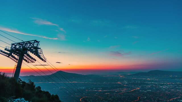 Magical sunrise above Athens with Parnitha Funitel cable tower on slope, timelapse