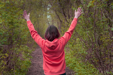 girl holds her hands up. woman in a pink body shirt. travel concept. illustration of hiking. person in nature