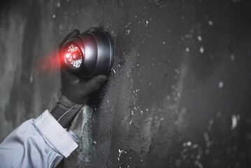 Video surveillance service worker is installing a cctv security camera on the wall close up.