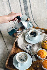 Morning coffee with pumpkin muffins on a wooden tray.
