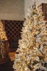 tall Christmas tree with gold decorations and garlands on the background of a wine cabinet. selective focus