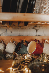 Fototapeta na wymiar many mugs in cozy wooden kitchen. Christmas mood. vertical, selective focus