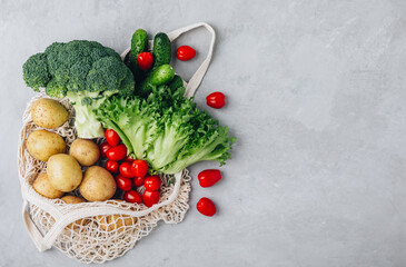 Mesh bag with vegetables. Organic Broccoli, celery, cucumbers, lettuce and potato in cotton shopper bag