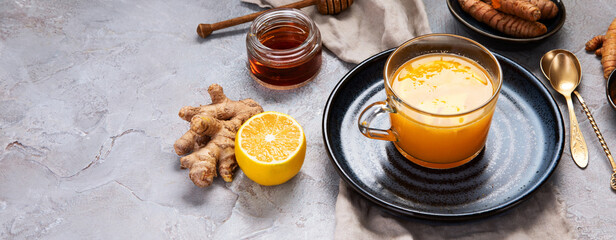 Obraz na płótnie Canvas Healthy turmeric golden tea on light gray background.