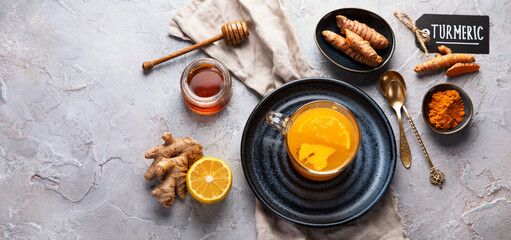 Healthy turmeric golden tea on light gray background.