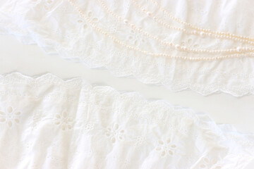 Background of white delicate lace fabric and pearls