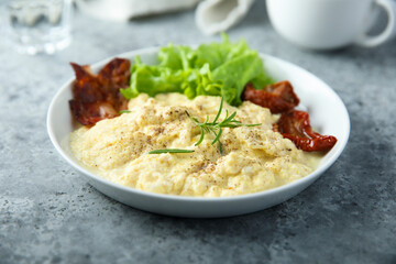 Homemade scrambled eggs with fried bacon