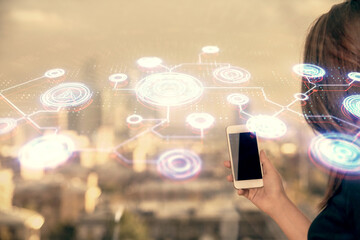 Double exposure of social network sketch hologram and woman holding and using a mobile device.