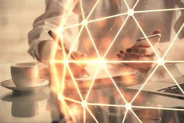 Double exposure of social network sketch hologram and woman holding and using a mobile device.