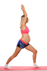 Fototapeta na wymiar Portrait of a beautiful young pregnant woman doing exercises in the studio