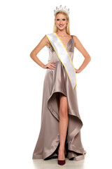 Naklejka premium young woman with a crown , evening dress and the winning ribon