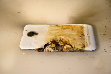 Not subject to recovery melted with fire mobile phone white on the table