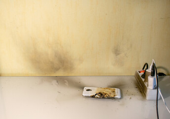 Mobile phone stained the wall, table, socket. Burned battery