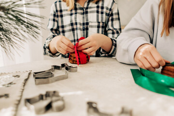 Close-up of the girl's hands tied with a red ribbon Christmas cookies. Preparation for the holidays, gifts, sweet treats