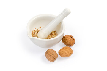 Crushed walnuts in kitchen mortar with pestle and whole nuts - obrazy, fototapety, plakaty