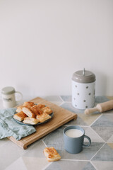 freshly baked homemade pastry on kitchen table. breakfast with puff buns and a glass of milk