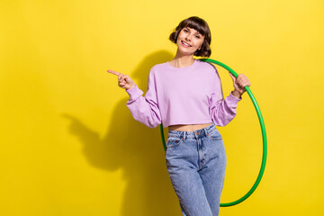 Portrait of attractive trendy cheerful girl holding hula hoop showing copy space isolated over...