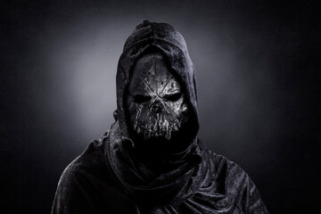 Fototapeta na wymiar Monster in hooded cloak at night over dark misty background