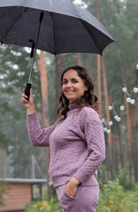 Portrait of Happy Young Woman Holding Umbrella in Autumn Rainy Day Outdoors
