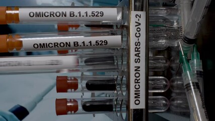 A close up vertical video of a medical professional wearing surgical gloves removing test tubes containing Omicron samples from a laboratory rack, the latest strain of Covid 19 found in South Africa