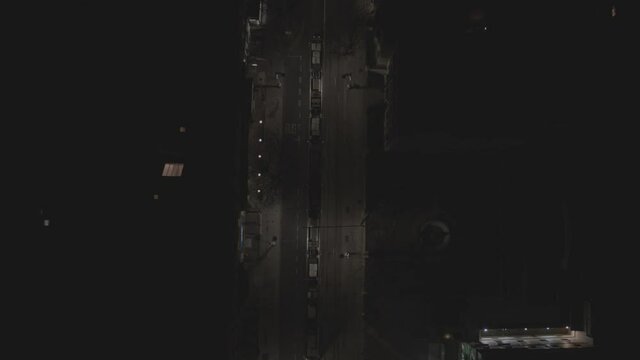 A flyover tracking shot that follows the Luas, an Irish Tram as it follows through the dark night time Dawson Street of Dublin, Ireland. The streets are only lit by the steet lights around it.