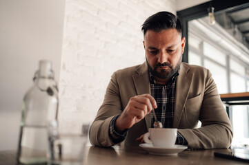 Handsome businessman drinking coffee in a cafe