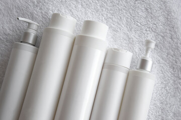 Bottles of professional natural cosmetics on the background of white towels.